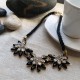 Collar de cuerda negra y flores geométricos