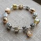 Pulsera con charms dorados y plateados y cierre dorada
